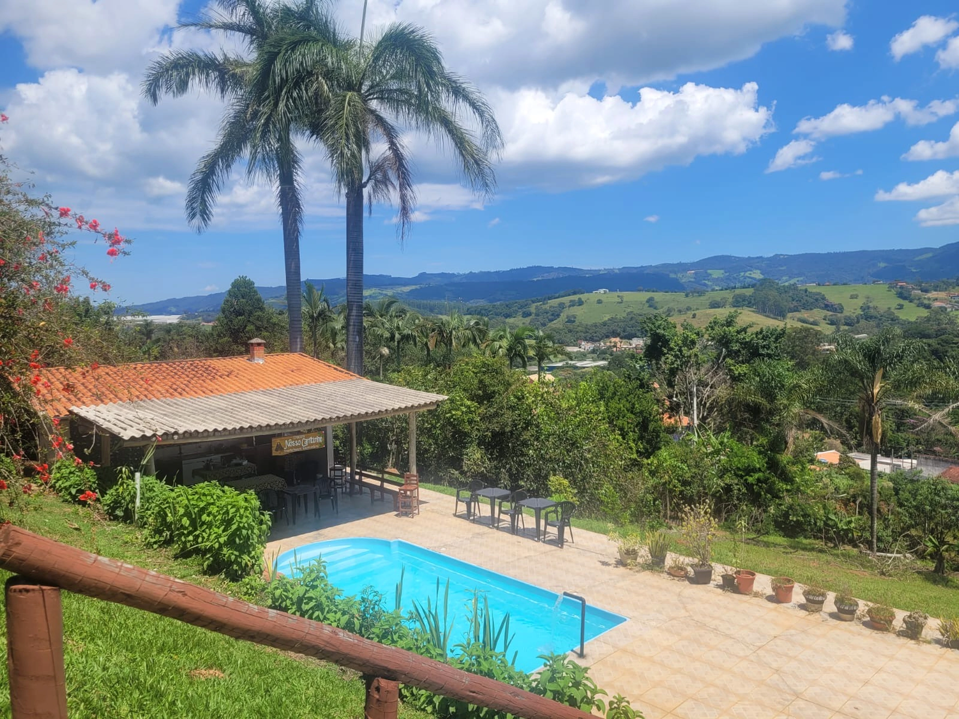 Vista da Chácara Nosso Cantinho com piscina e montanhas